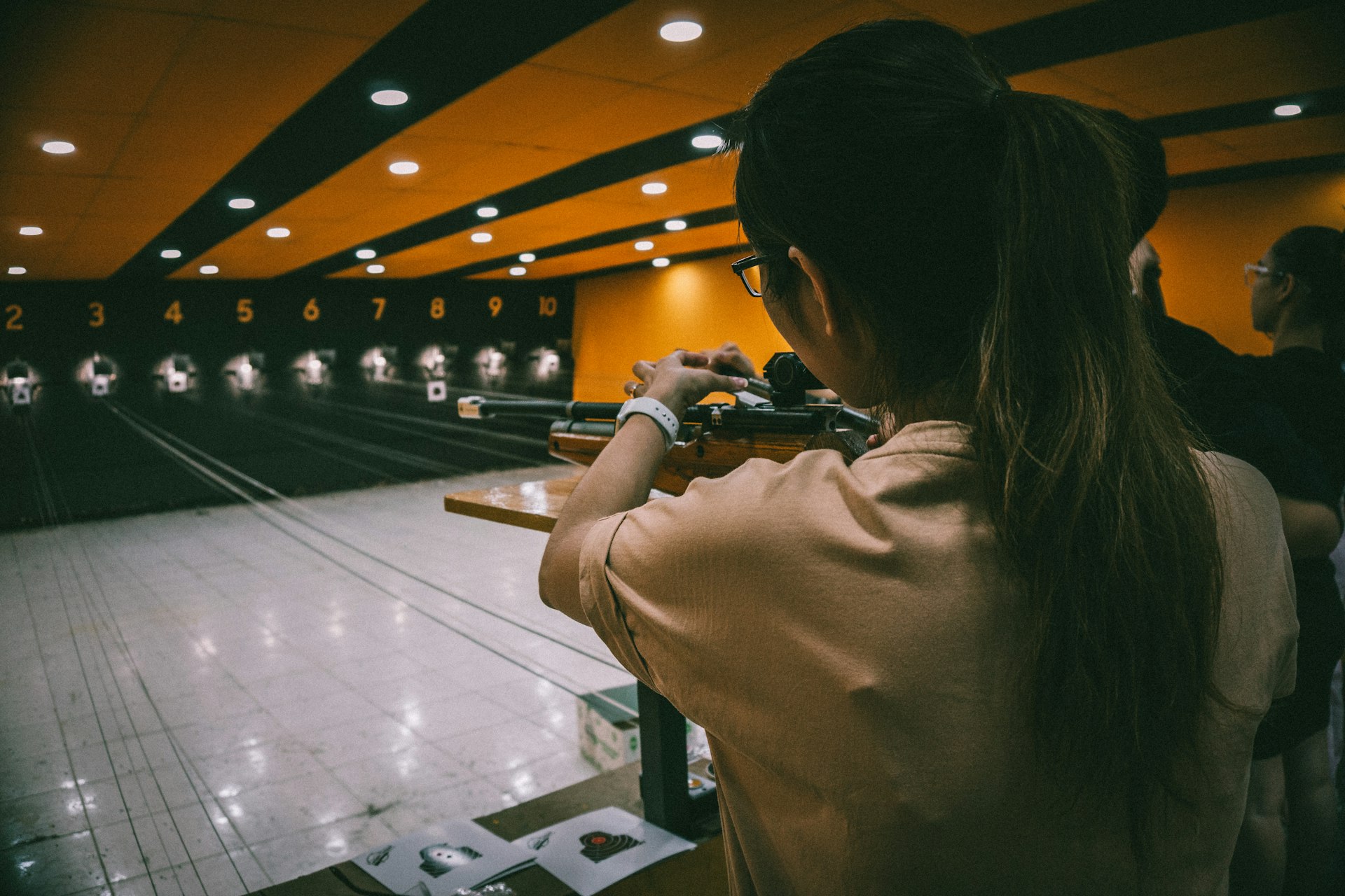 a woman is aiming a gun at a target